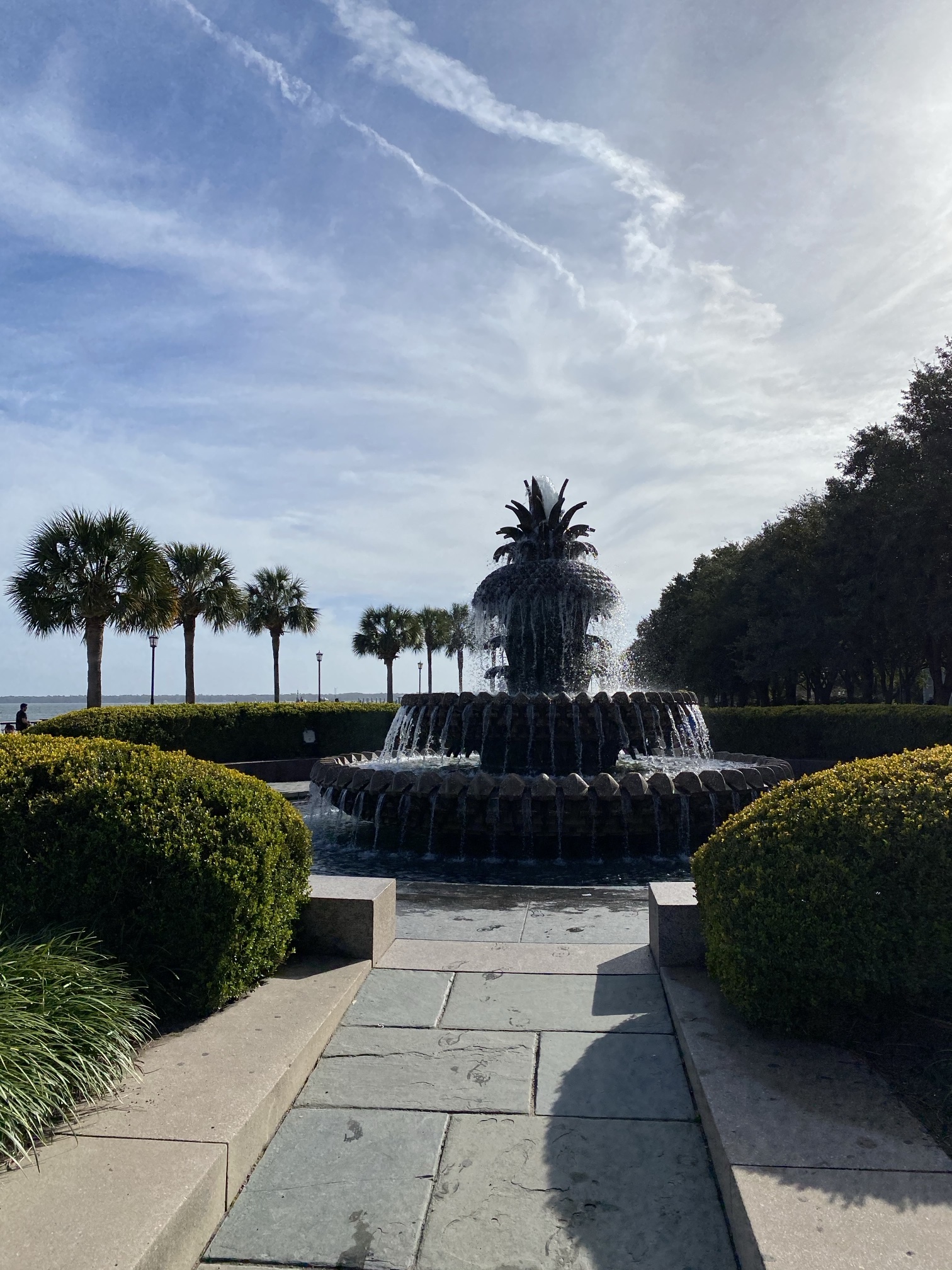 The Pineapple Fountain in Waterfront Park, with palmettos and the harbor behind it