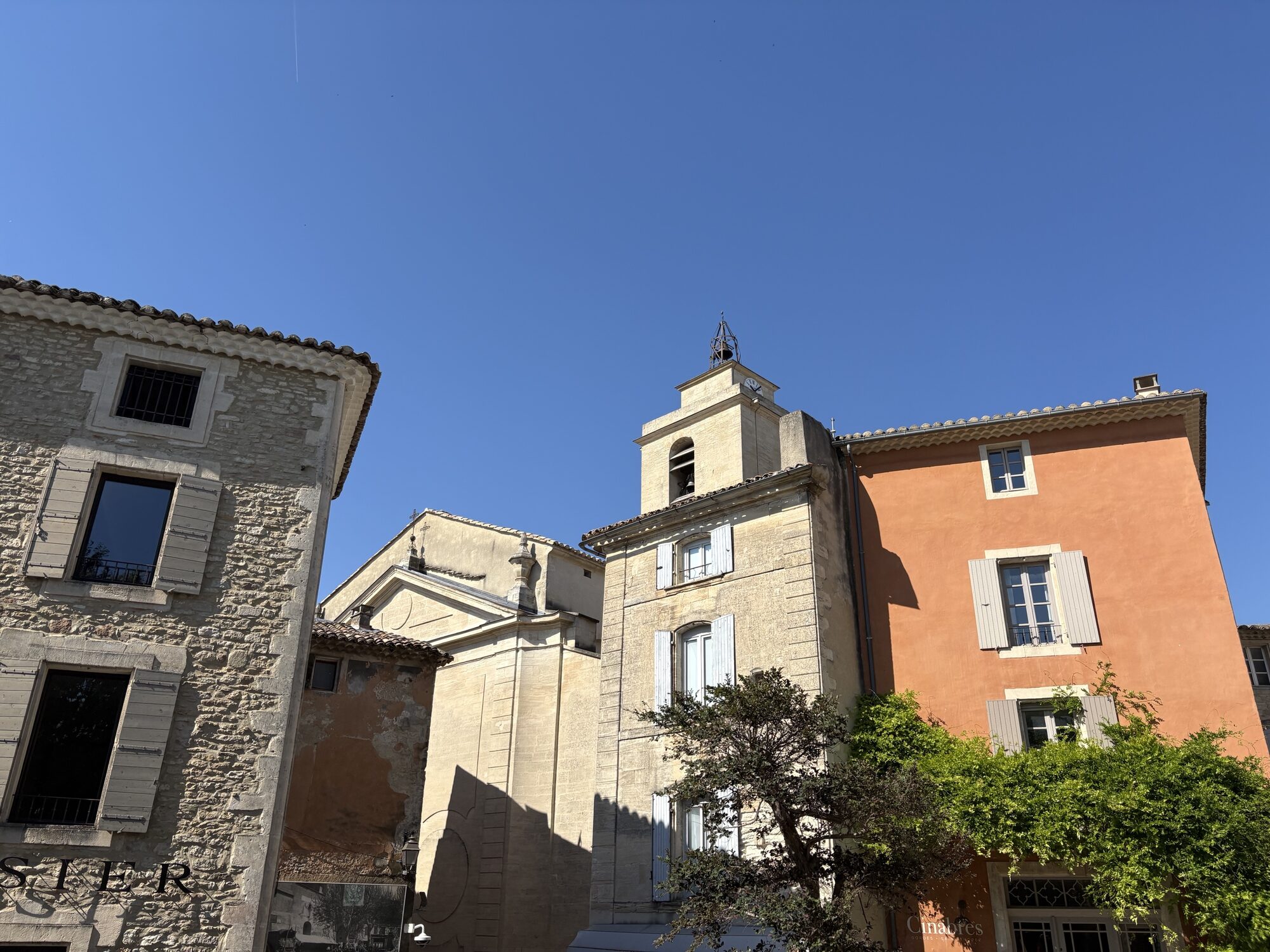 Stone and ochre-painted houses around the bell tower in Gordes